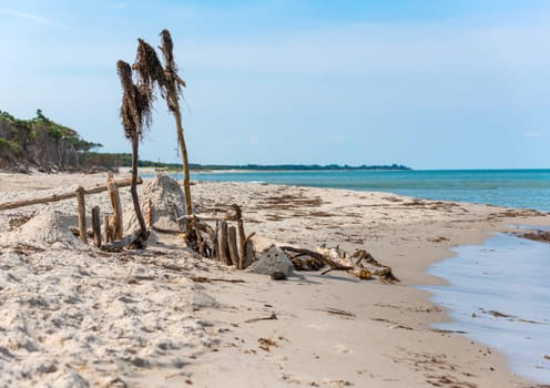 German Baltic Sea coast with sand dunes, grass, water and blue sky with Wood sign
