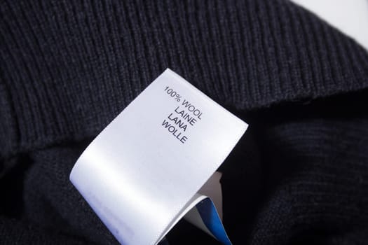100 wool label on the sweater dark blue wool fabric.