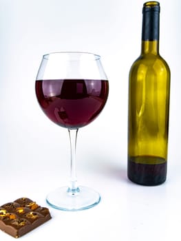 Glass of red wine and chocolate on a white background. Food and drinks. Place for text.