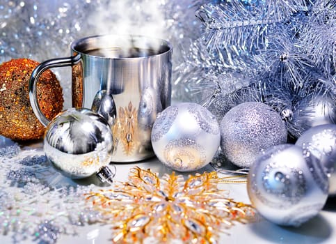 Christmas decoration with balls, tree and a cup of hot coffee.