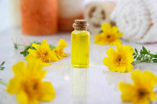 Flower essence in a small bottle with fresh marigold flower