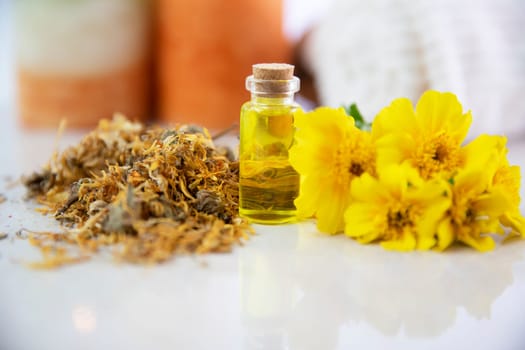 Flower essence in a small bottle with fresh and dried marigold flower