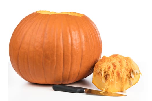 Pumpkin with top removed and knife isolated on a white background