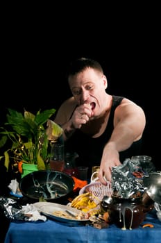 adult  man in black shirt sits behind dirty table