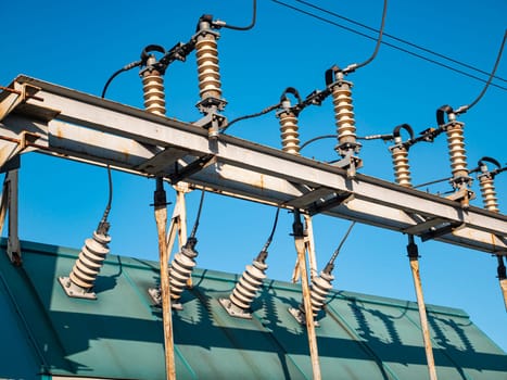 High voltage power line against the blue sky. Industrial landscape. Place for text.