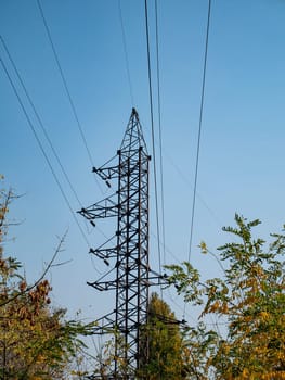 High voltage power line against the blue sky. Industrial landscape. Place for text.