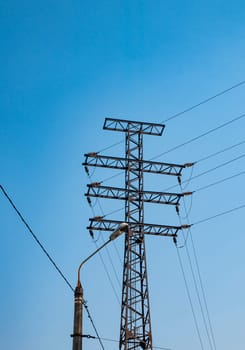 High voltage power line against the blue sky. Industrial landscape. Place for text.