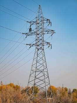High voltage power line against the blue sky. Industrial landscape. Place for text.