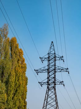 High voltage power line against the blue sky. Industrial landscape. Place for text.