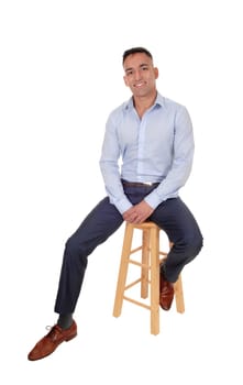 A happy east Indian man sitting relaxed on a chair taking a break, .smiling, in a blur dress shirt, isolated for white background.