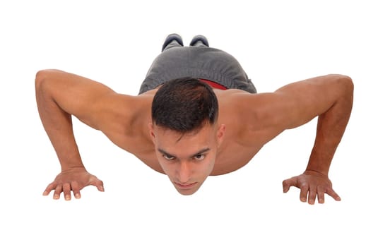 A young east Indian man doing his push aps on the floor in the studio.isolated for white background.