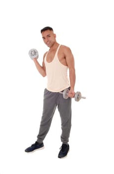 A handsome east Indian man standing in track pants working with.two dumbbells, isolated for white background.