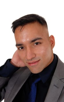 A closeup image of a handsome young east Indian man in a gray suit,.black shirt and blue tie, isolated for white background.