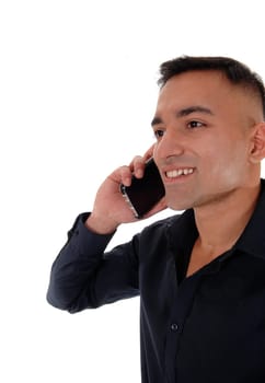 A smiling happy young man in a black shirt standing in the studio.with his phone on his ear and talking, isolated for white background.