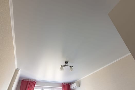 Stretched white matte ceiling in the room close-up