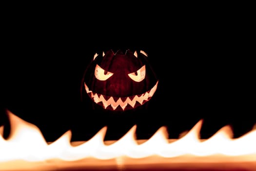 Big helloween autumn symbol with mad face, glowing eyes, mouth and teeth. Scary hot nightmare horror with evil smile at october 31st.