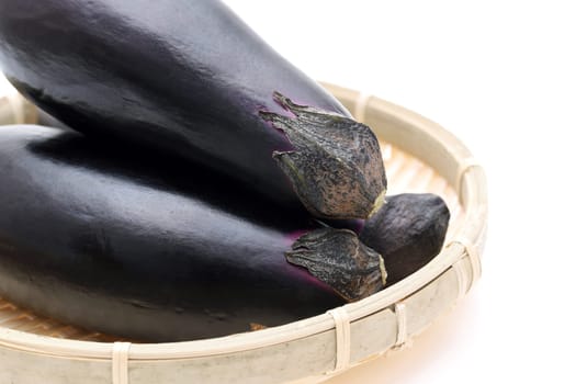 Japanese fresh eggplants on bamboo basket on background