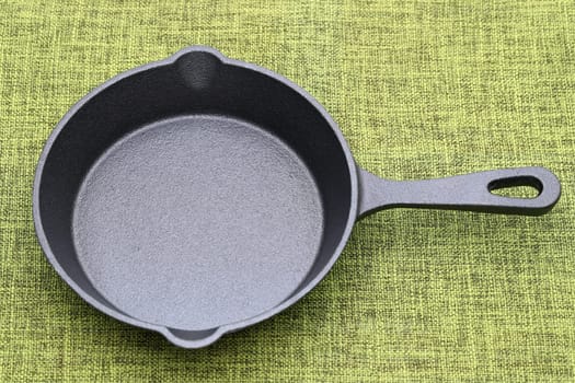 Empty small iron frying pan on kitchen table