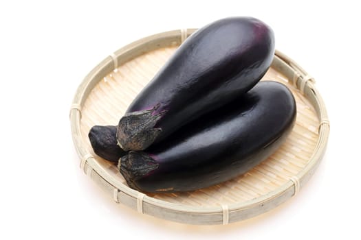 Japanese fresh eggplants on bamboo basket on background