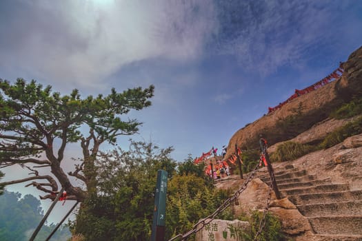 Huashan, China -  August 2019 : Cut in a rock stone stair steps leading to the summit of a West Peak on Huashan mountain, Xian, Shaanxi Province