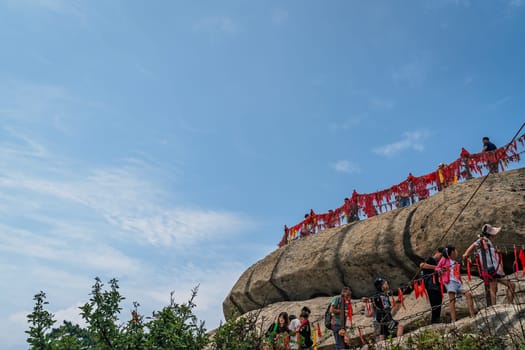Huashan, China -  August 2019 : Crowds of tourists standing on the scenic viewing platform at the summit of a West Peak on Huashan mountain, Xian, Shaanxi Province
