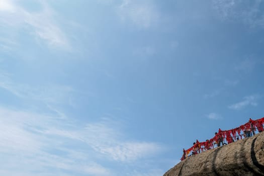 Huashan, China -  August 2019 : Crowds of tourists standing on the scenic viewing platform at the summit of a West Peak on Huashan mountain, Xian, Shaanxi Province