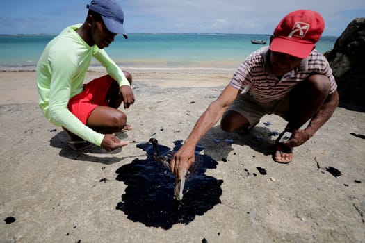VERA CRUZ, BAHIA / BRAZIL - October 18, 2019: People obsessed with oil macha on Sol Beach, the place was affected by oil spills at sea (Joa Souza / Panthermedia).