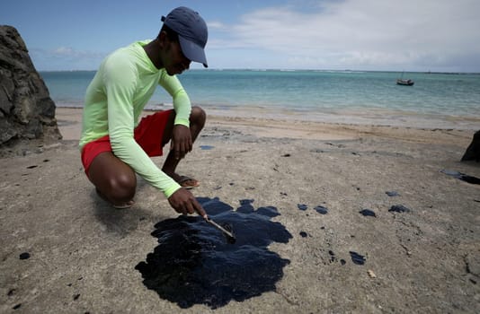 VERA CRUZ, BAHIA / BRAZIL - October 18, 2019: People obsessed with oil macha on Sol Beach, the place was affected by oil spills at sea (Joa Souza / Panthermedia).