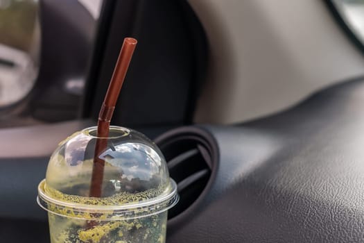 Ice milk green tea famous drink in a car blurred background