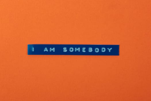 I am Somebody text with a labelprinter on orange cardboard