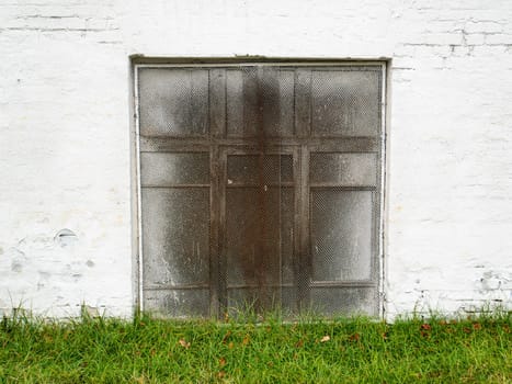 Window with a lattice in a white wall. Place for text. Background image.