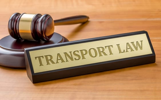 A gavel and a name plate with the engraving Transport law
