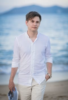 Outdoor portrait of a handsome young man walking near the sea