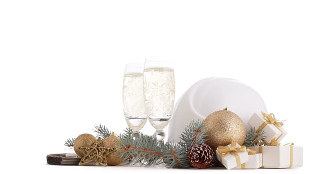 Construction hard hat, fir tree branches, two glasses with champagne, gift boxes and Christmas ornament isolated on a white background. New Year and Christmas construction background