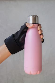 Fitness glove hand on water bottle, stock photo