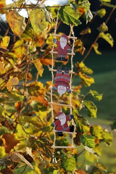 A Santa Claus decoration on an autumn tree with colourful foliage