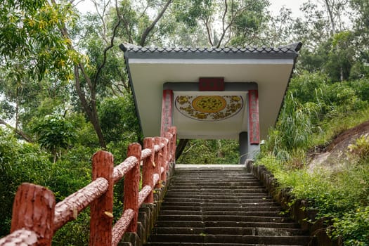 A stone staircase in a pagoda on a hill with the inscription in the middle "Prayer place"" and on the sides ""Always welcome"", Shenzhen, China"