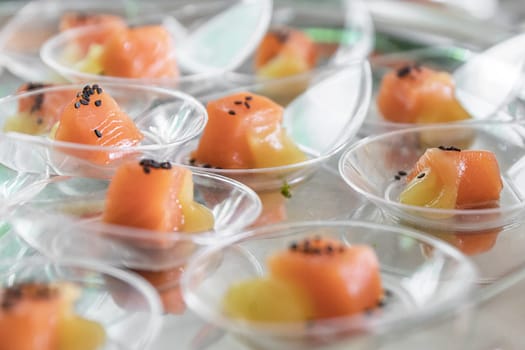 Transparent glasses with salmon on silver plate. .Starters buffet prepared for an event, party or wedding.