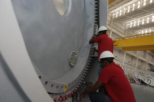 SIMOES FILHO, BAHIA / BRAZIL - May 13, 2015: Acciona Windpower wind turbine factory employees are seen working. (Joa Souza / Panthermedia).