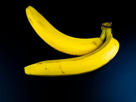Yellow bananas on a black background. Place for text.