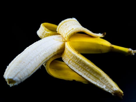 Yellow bananas on a black background. Place for text.