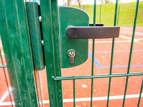 Internal lock with a handle on an iron street gate. Place for text.