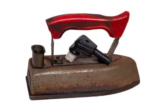 Close-up of a professional old rusty electric tailor iron or flatiron with a red handle and vintage power plug isolated on a white background. Tailoring accessories 50's years.