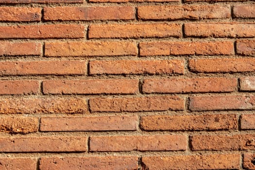 Stone texture background. Closeup of a old red brown of a weathered brick wall texture with a hilly uneven surface. Abstract background concept.