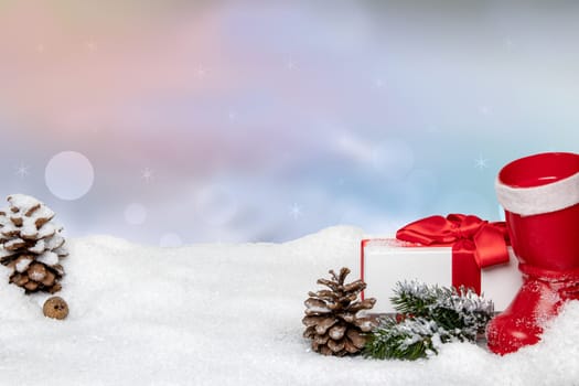 Christmas greeting card template. Santa boot with spruce branch, gift box, cones and a hedgehog in a snowy landscape against abstract winter sky with snow and stars. New year winter holiday concept. Space.