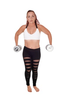 An exercising pretty woman standing in workout outfits and lifting.up the two dumbbells in her hand, isolated for white background.