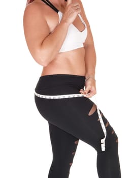 A beautiful woman in sports outfit standing in profile and measuring.her butt, isolated for white background.