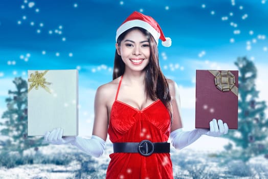 Asian woman in Santa costume holding gift box with snowfall background