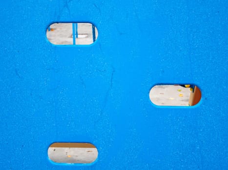 Blue plastic background with holes. Place for text.