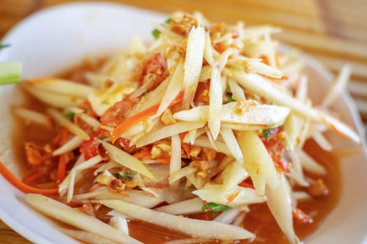 Papaya salad or Som tam in Thai street food blurred background